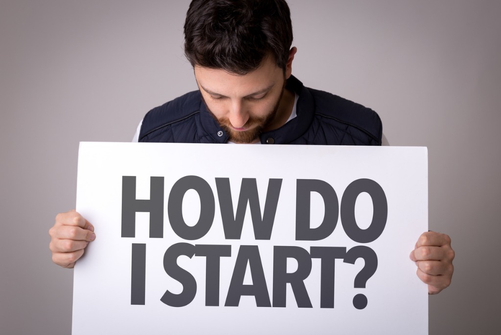 Man holding How do I start sign? Man holding How do I start sign?